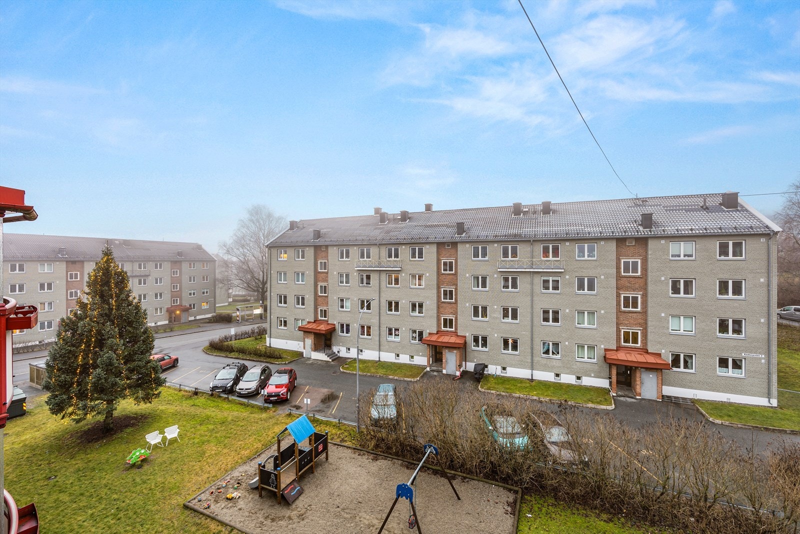 Fra leiligheten er det utsikt mot fellesarealene hvor det er en nyere lekeplass mellom blokkene. Galleribilde