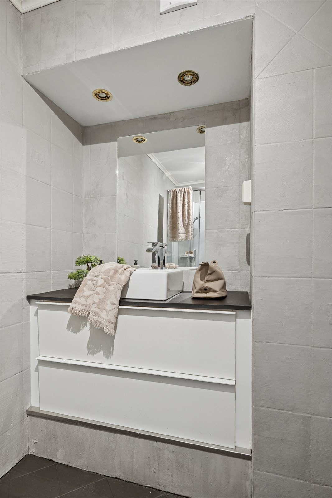 Baderomsinnredningen er pent utført med hvite, glatte fronter, romslige skuffer og benkeplate med servant. Over innredningen er det speil med tilhørende belysning. Galleribilde