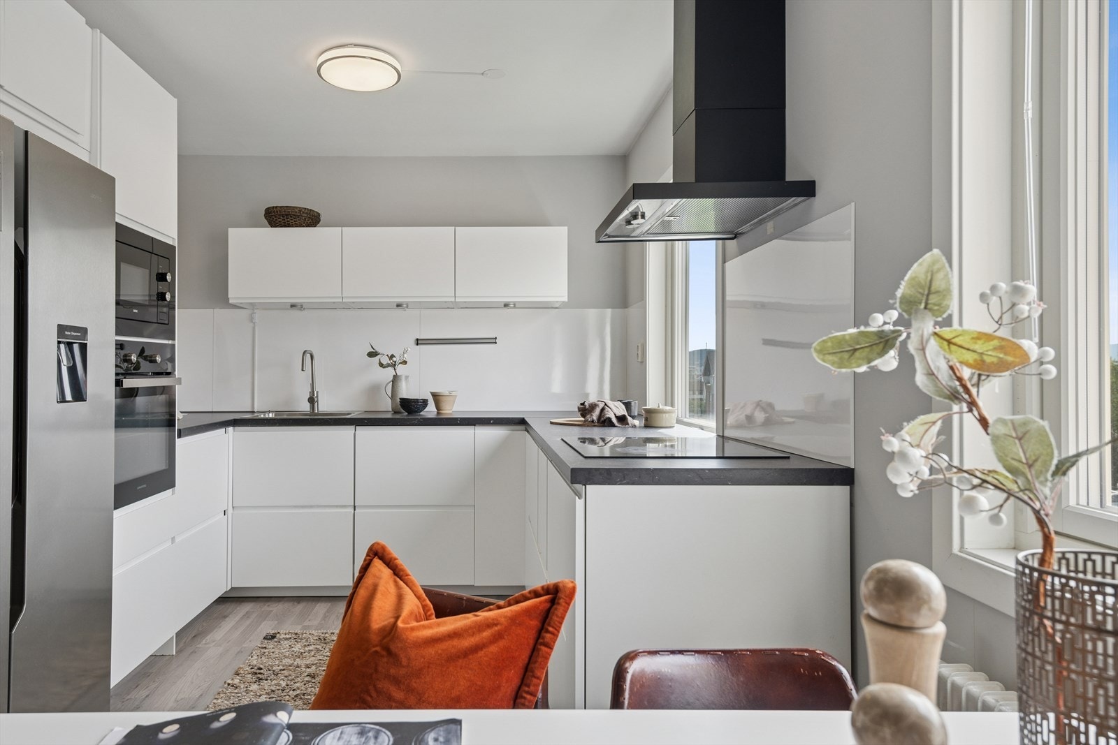 Kjøkkeninnredningen er fra 2019 og er moderne utført med hvite, glatte fronter og mørk laminert benkeplate med nedfelt kjøkkenkum. Galleribilde