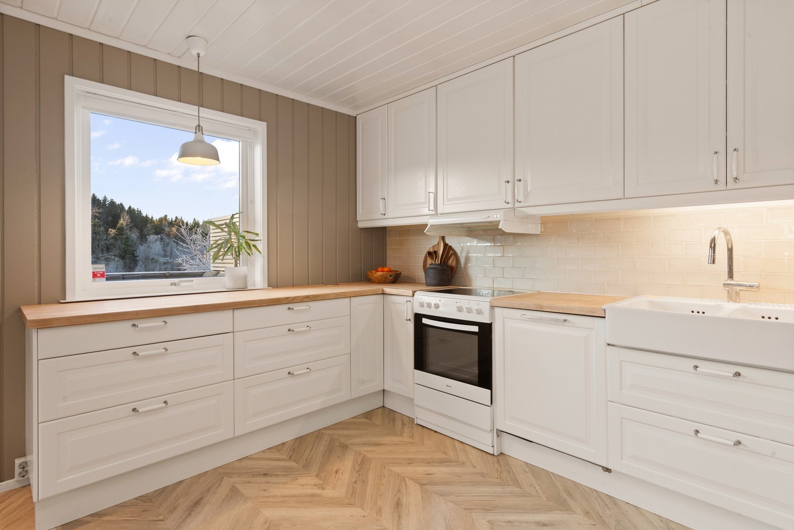 Kjøkkenet har en klassisk og fin innredning med porselens vask. Galleribilde