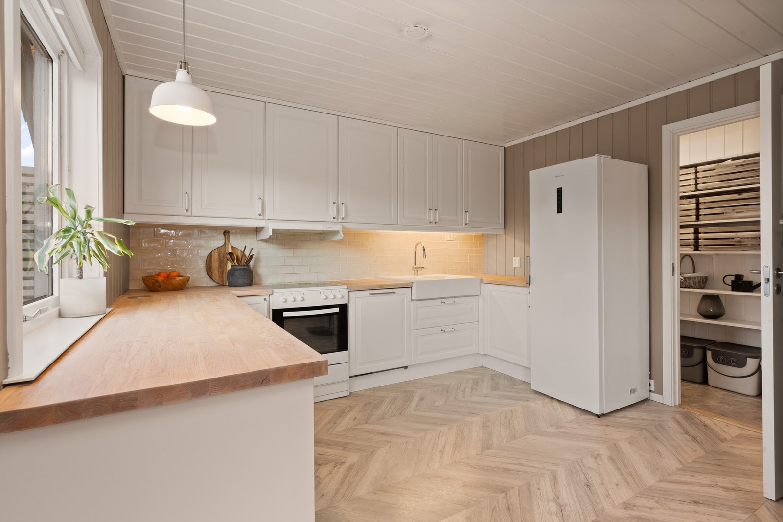 Kjøkkenet har godt med benkeplass og masse oppbevaringsplass i grovkjøkkenet Galleribilde