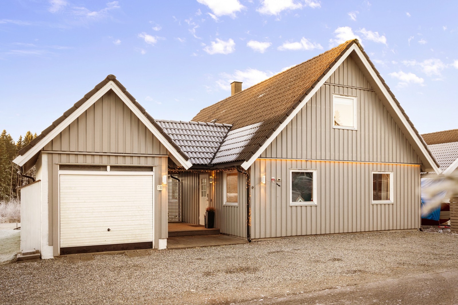 Boligen har en enkel garasje og overbygd inngangsparti Galleribilde