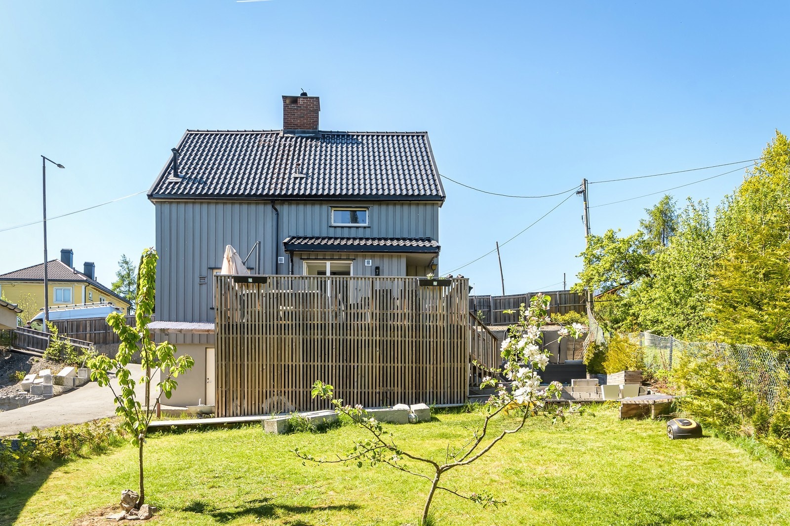 Pent opparbeidet hage med gressplen, beplantning og gjerde. Galleribilde