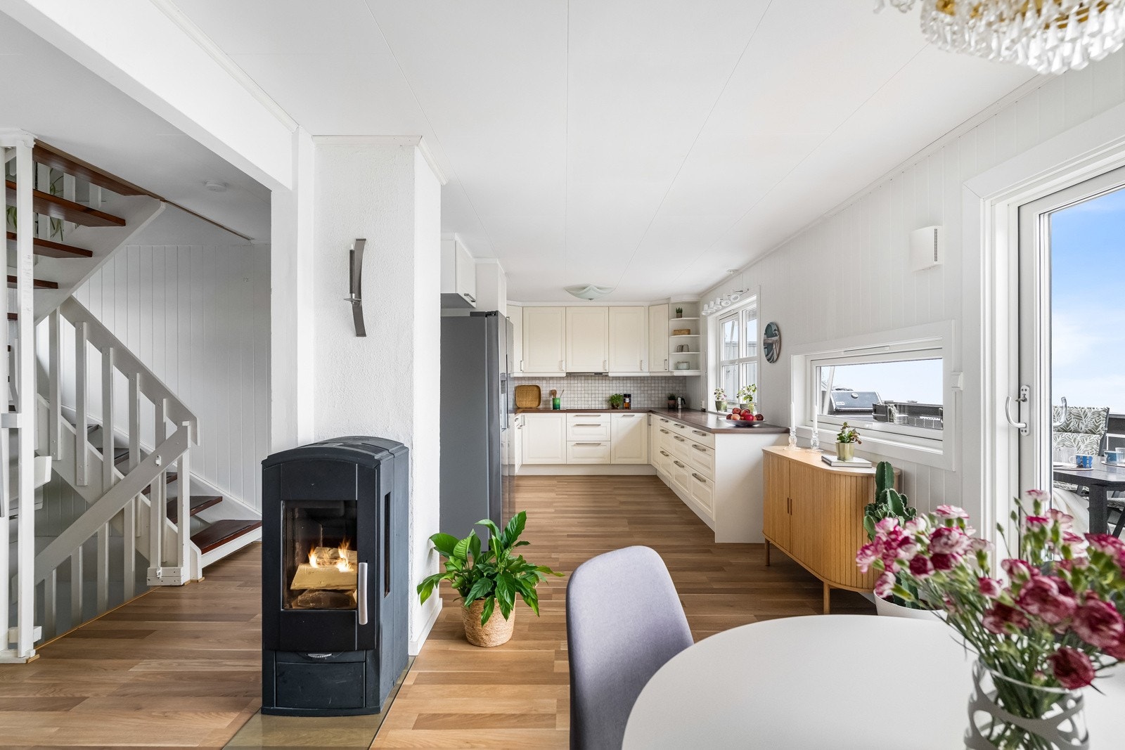 Delvis åpen løsning mellom kjøkken og stue. Kjøkkeninnredning 2011 med profilerte fronter. Galleribilde