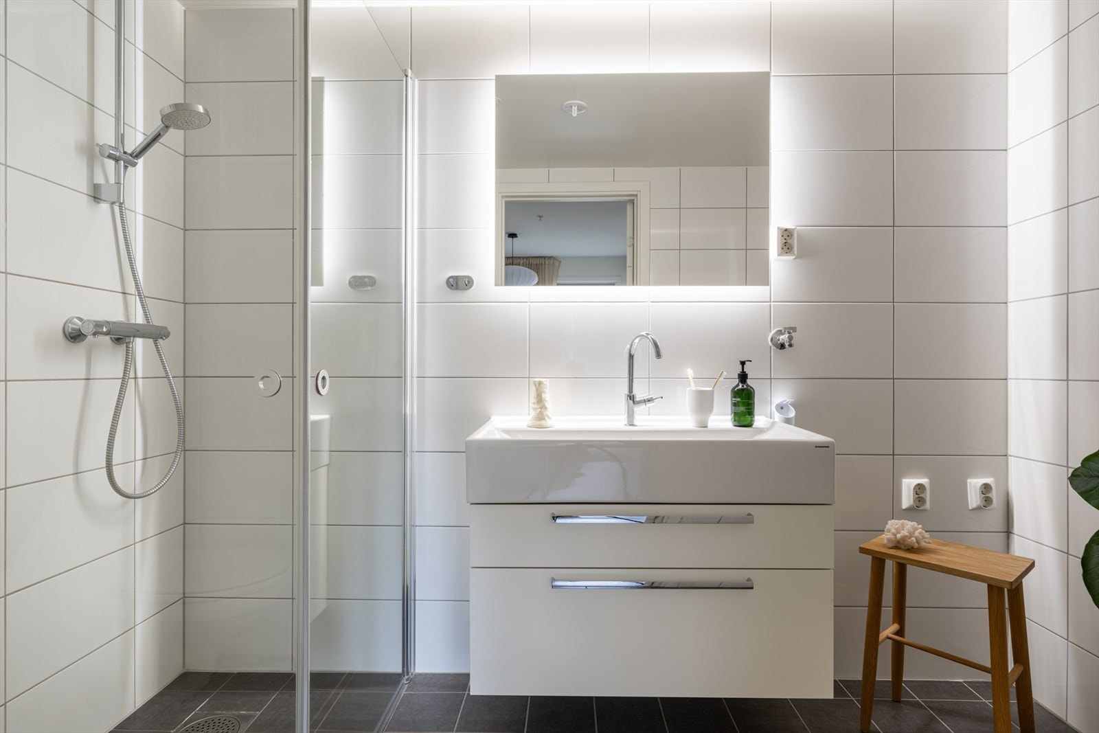 Det private badet er helfliset og utstyrt med dusjhjørne og vegghengt toalett. Galleribilde