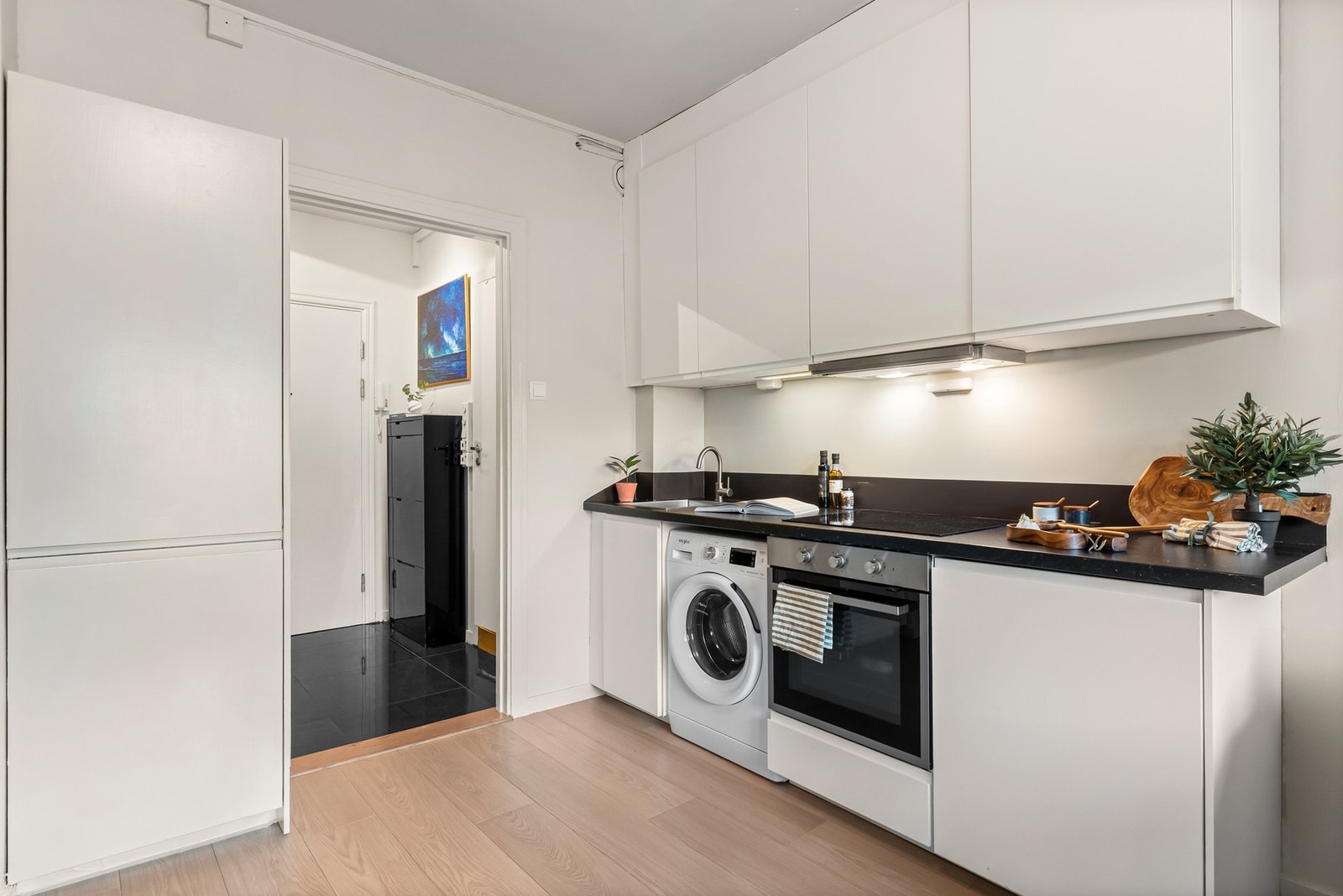 Kjøkkenet fra 2020 er utstyrt med hvit glatt kjøkkeninnredning, laminat benkeplate, malte flater over benk, utslagsvask med ett-greps blandebatteri,
kjøkkenventilator og vaskemaskin. Galleribilde