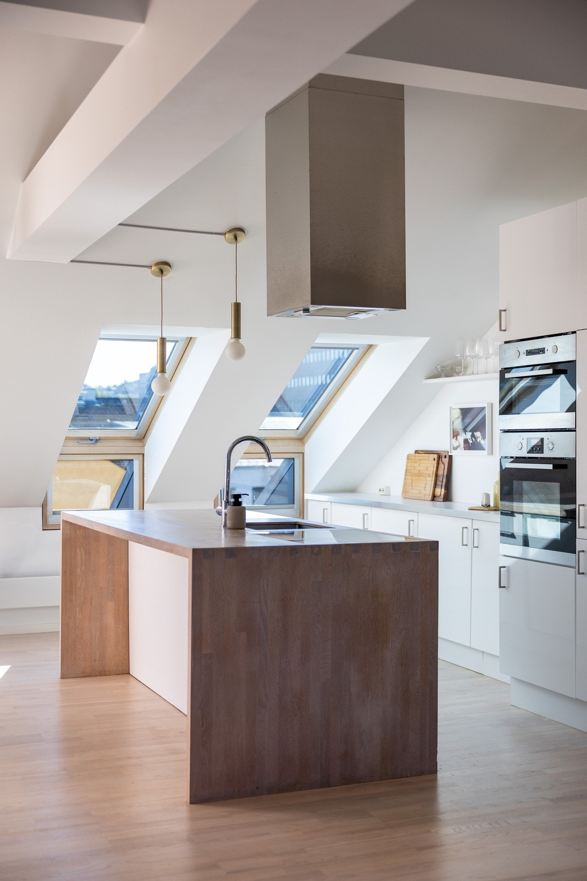 Lekkert kjøkken med kjøkkenøy som skaper et naturlig skille i rommet. Galleribilde