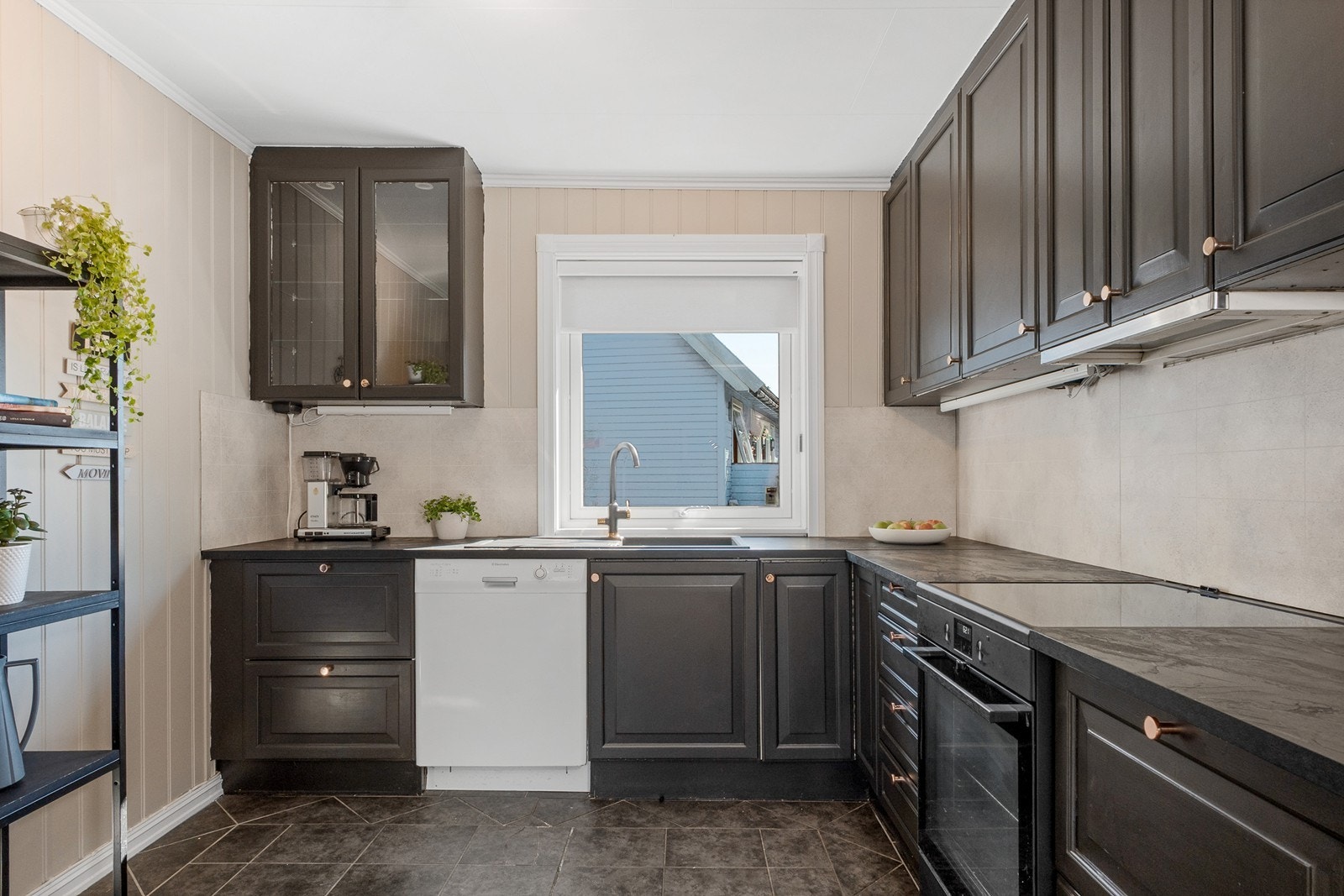 Innredningen består av sorte fronter, benkeplate av laminat med komposittkum og matchende laminatplate på vegg over benk. Galleribilde