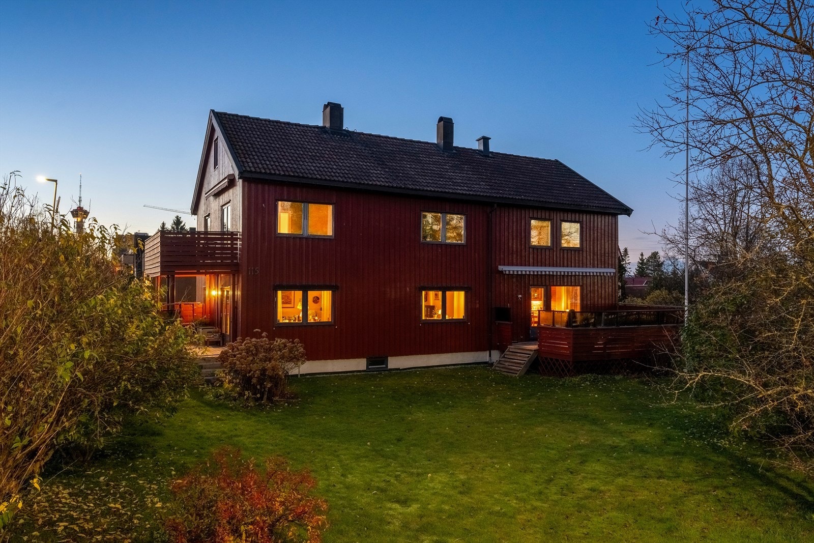 Nydelig opparbeidet hage med plen, prydbusker og trær som skjermer for trafikk og forbipasserende. Galleribilde