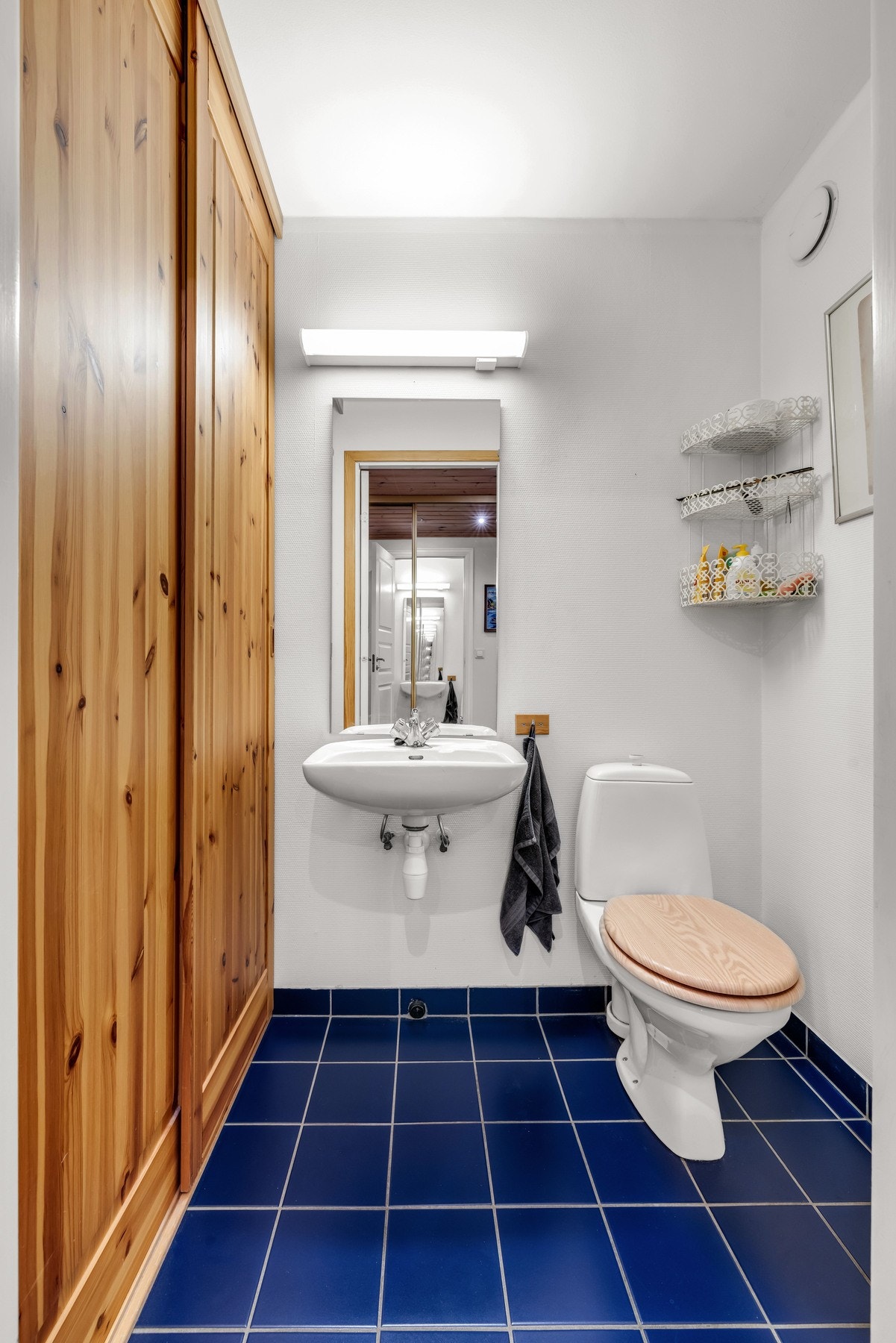 Leiligheten har også et eget toalettrom med flislagt gulv som inneholder gulvmontert toalett og servant Galleribilde