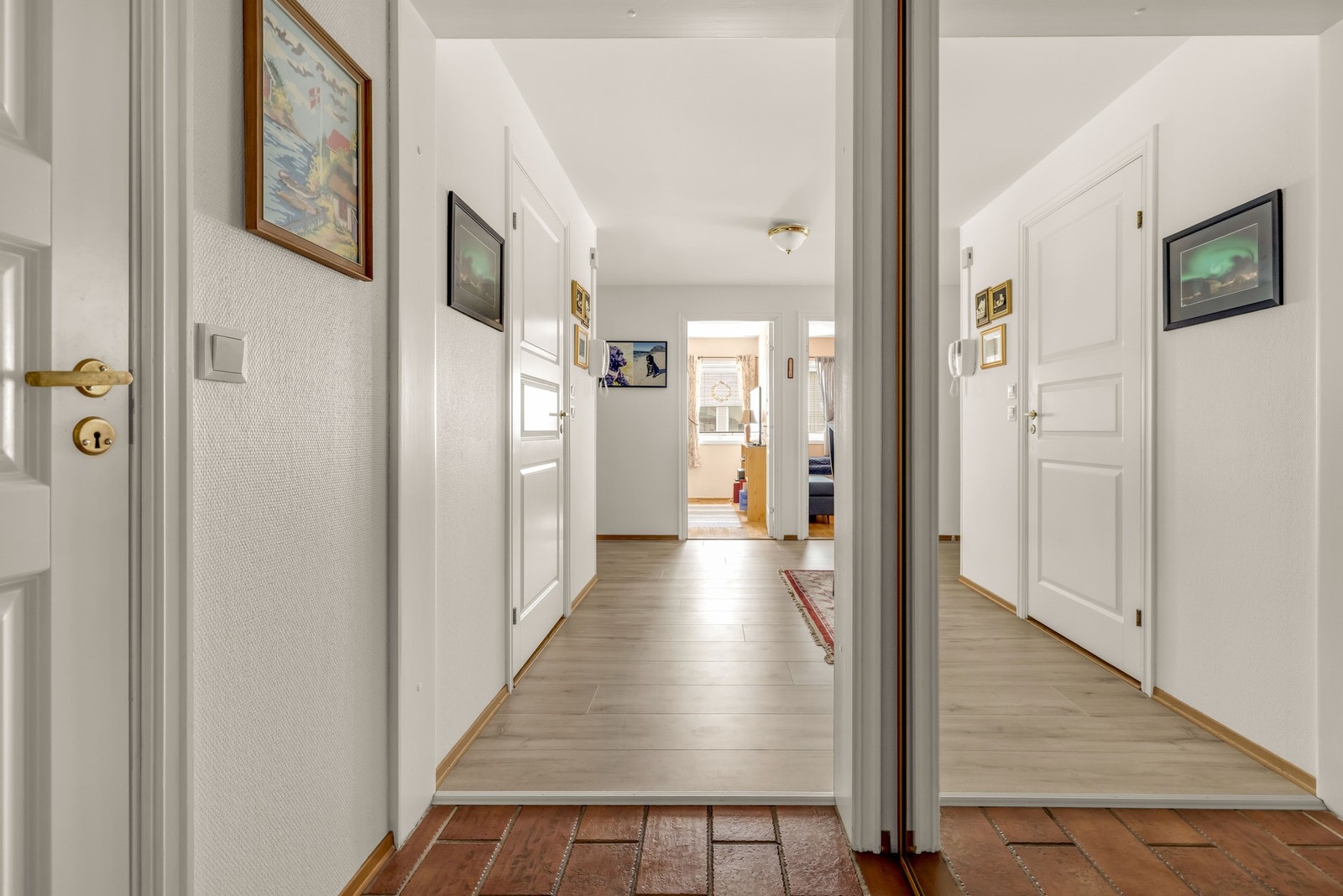 Leiligheten har en romslig gang med flislagt gulv og plassbygd skyvedørsgarderobe Galleribilde