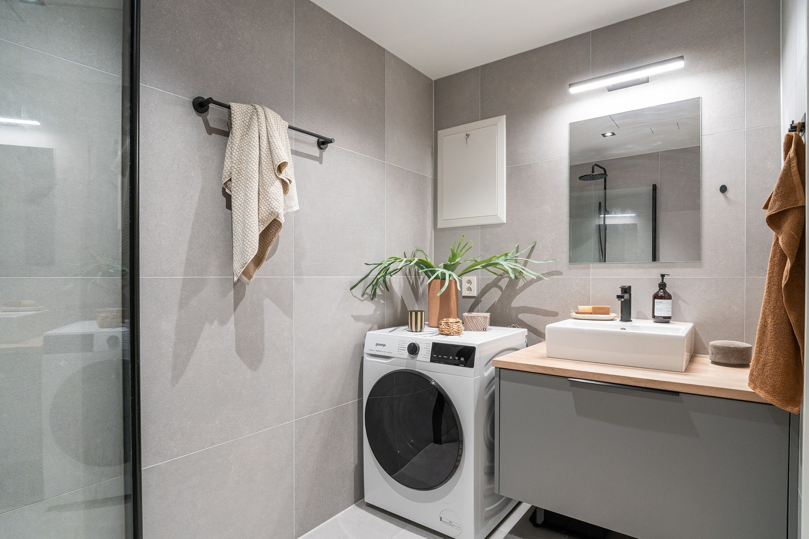 Bad inkluderer dusjnisje, veggmontert servantskap, toalett, samt opplegg for vaskemaskin Galleribilde