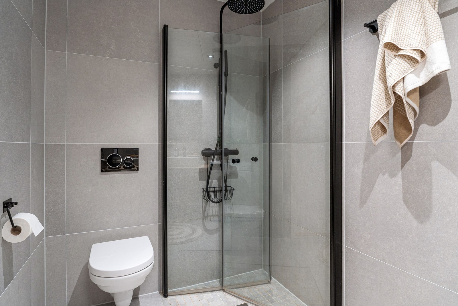 Lyse grå fliser i størrelse 60 cm x 60 cm, fra Ceramica Di Sassuolo, type Abaco Grey Light, samt mosaikkfliser i dusjnisjen Galleribilde