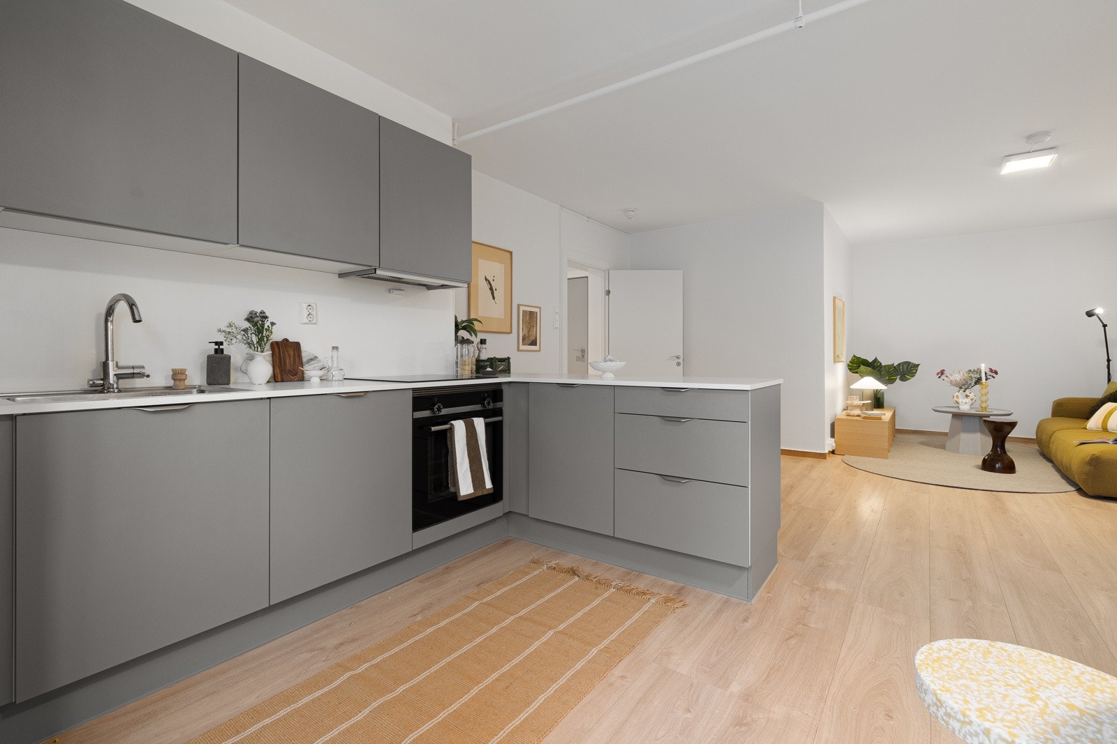 . Videre er kjøkkenet utstyrt med integrerte hvitevarer som komfyr, oppvaskmaskin samt kombinert kjøl- og fryseskap, noe som gir en helhetlig og moderne kjøkkenløsning. Galleribilde