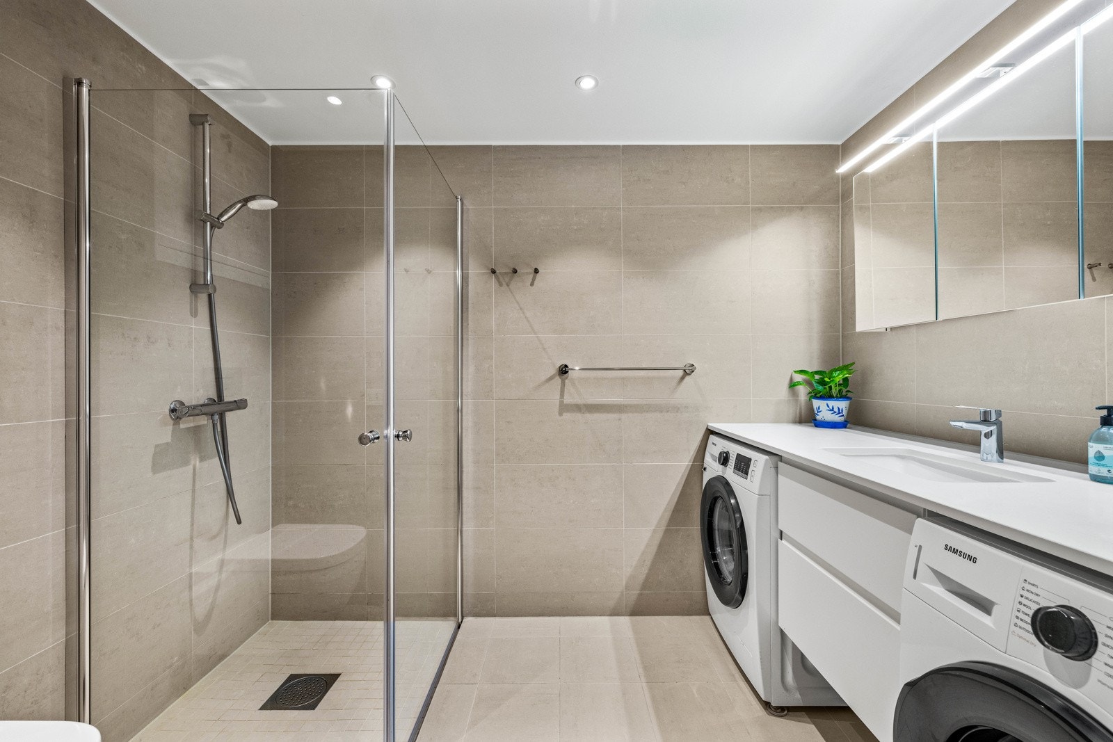 Pent, flislagt baderom med behagelig varme i gulvet og downlightsbelysning. Galleribilde