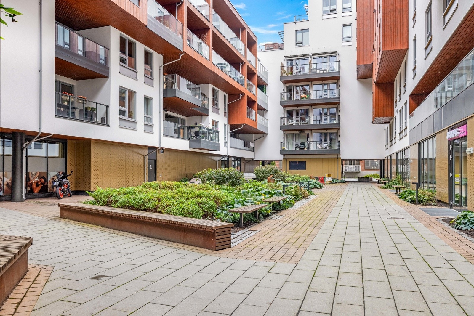 Mellom byggene ligger et lunt og hyggelig atrium som fungerer som en grønn oase midt i sameiet. Galleribilde