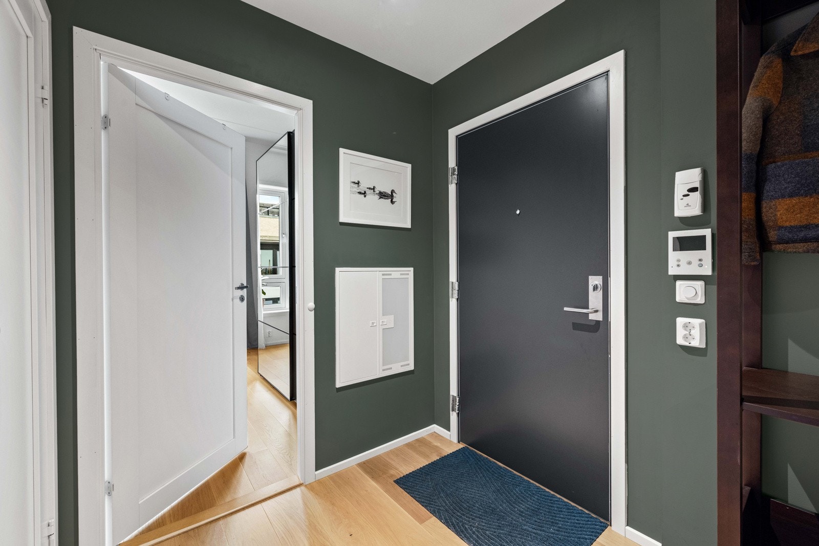 Entreen gir et godt førsteinntrykk av leiligheten med lune fargetoner, parkettgulv, downlights i taket og god plass til å henge fra seg ytterjakken. Galleribilde