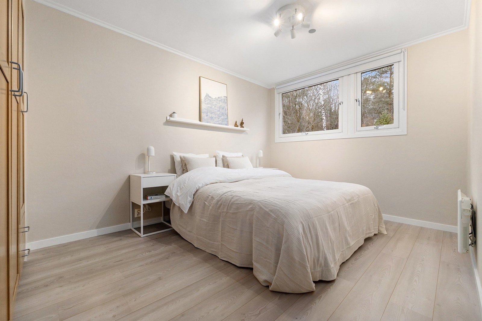 Lyst og romslig hovedsoverom med rikelig av plass til dobbeltseng og tilhørende nattbord Galleribilde