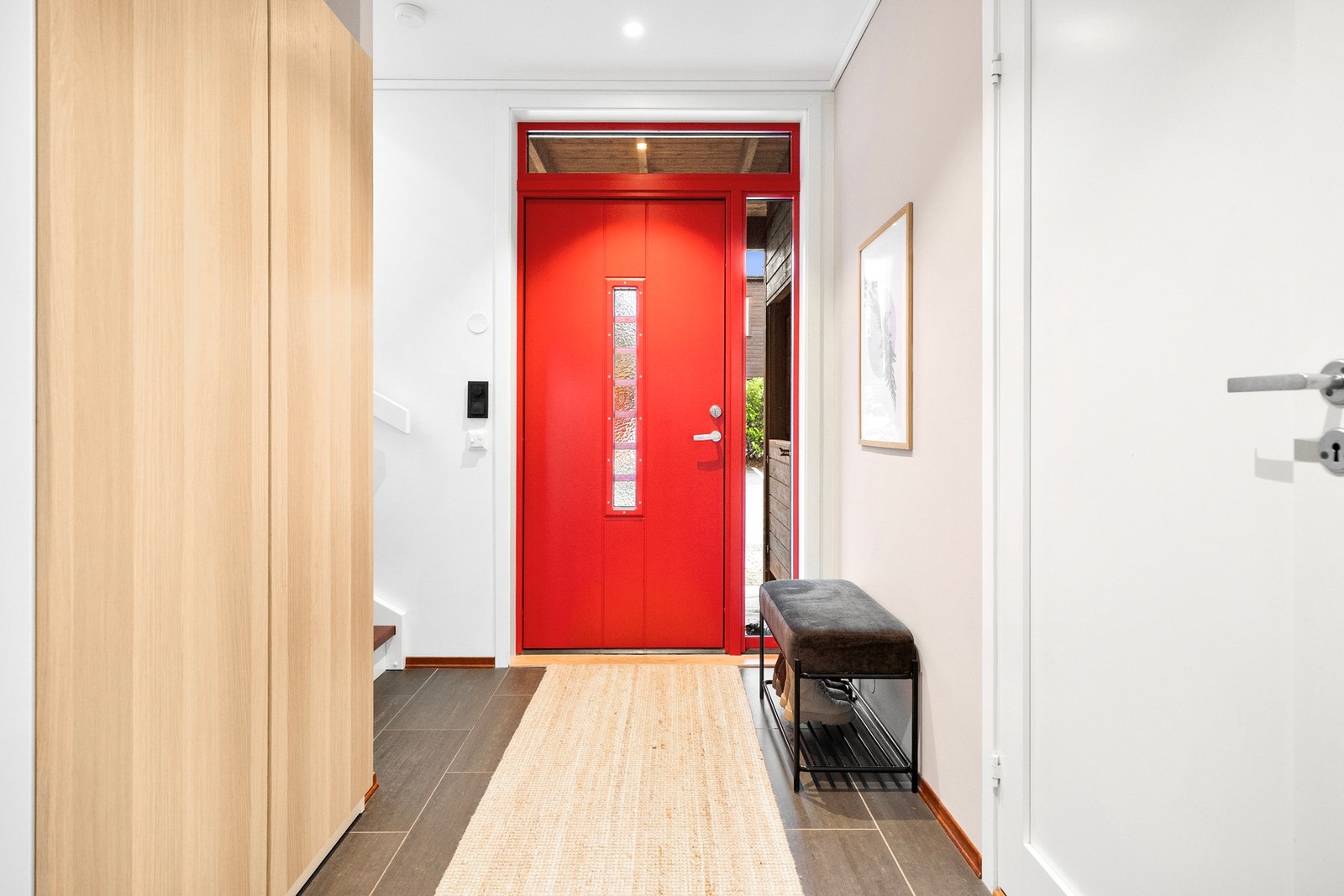 Lys entré med fliser på gulv og garderobe Galleribilde