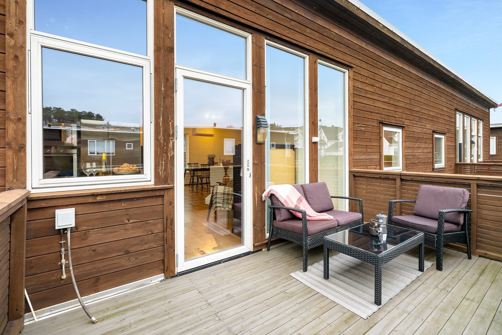 Stor terrasse ut fra kjøkken med plass til sittegruppe og grill Galleribilde