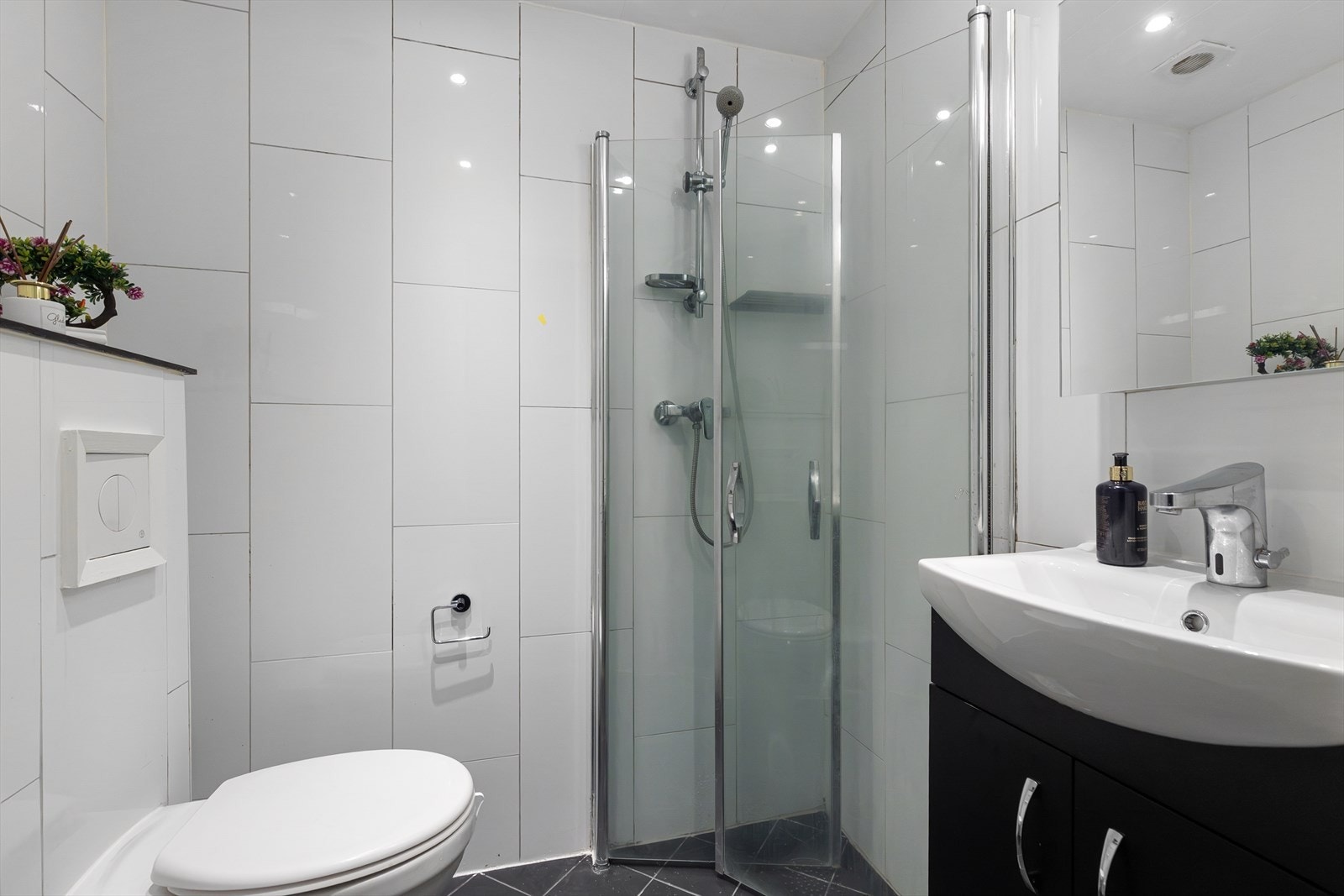 Baderom 2 ligger også i underetasjen. Det er vegghengt klosett, dusjhjørne med svingbare glassdører og servent med underskap og speilskap. Galleribilde