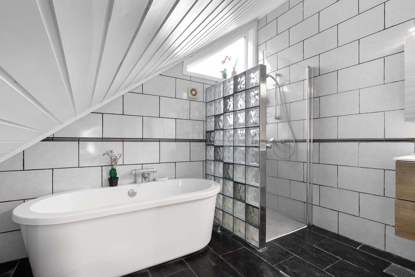 Baderommet har praktisk dusjnisje og fint baderkar Galleribilde