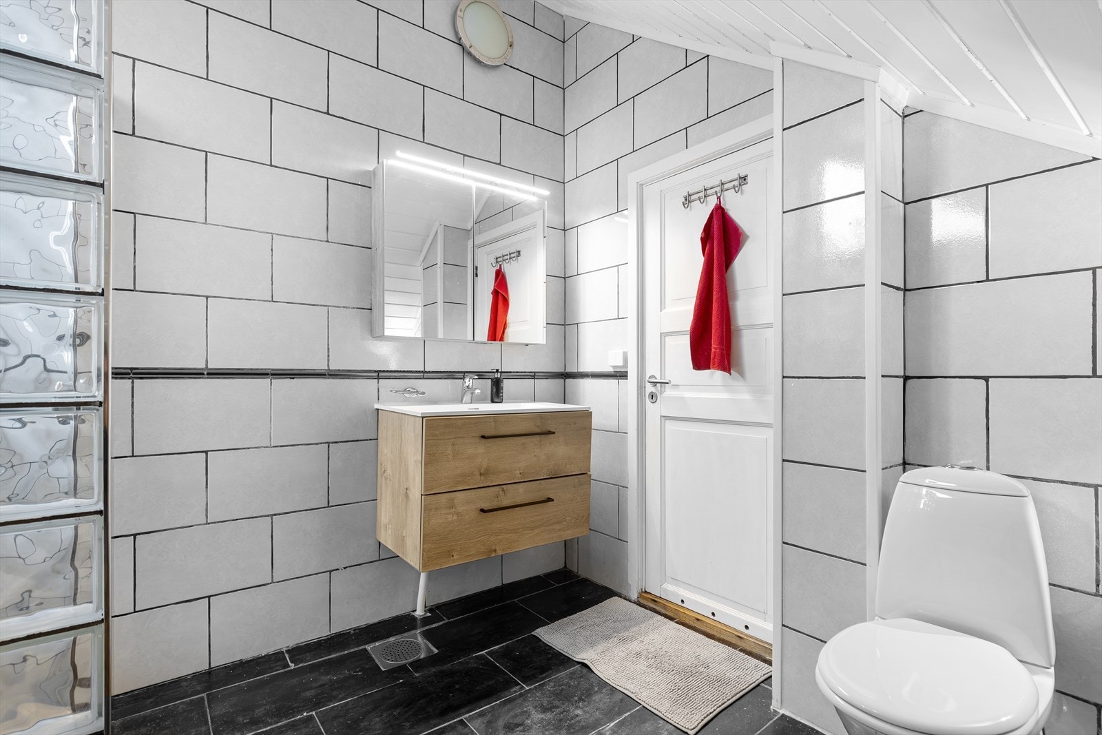 Det er servant og servantskap , samt overskap med speil og belysning Galleribilde