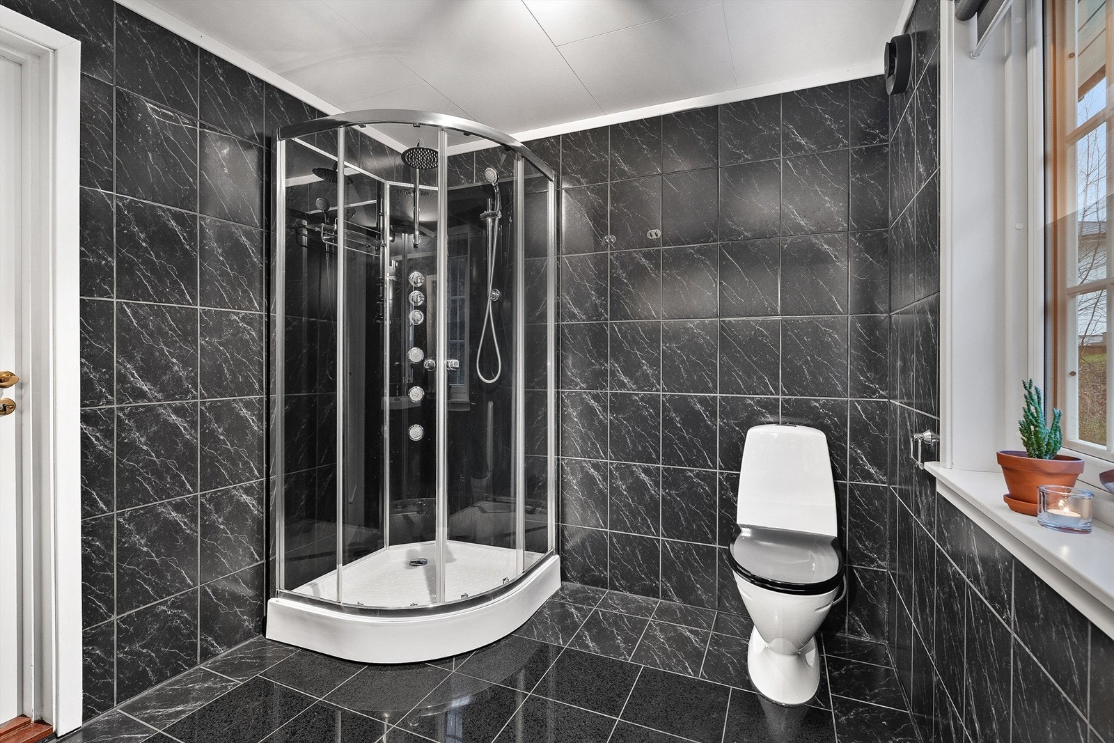 Dusjkabinett i hjørnet og gulvmontert toalett Galleribilde