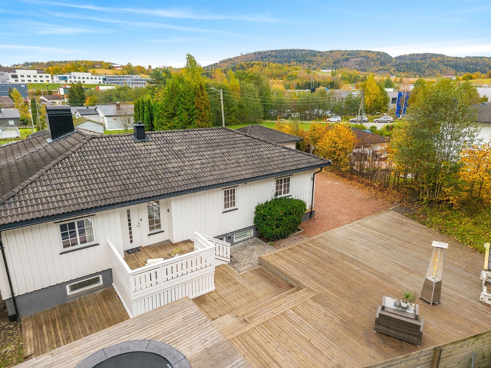 Baksiden av tomten er opparbeidet med stor platting og skjermede utearealer Galleribilde