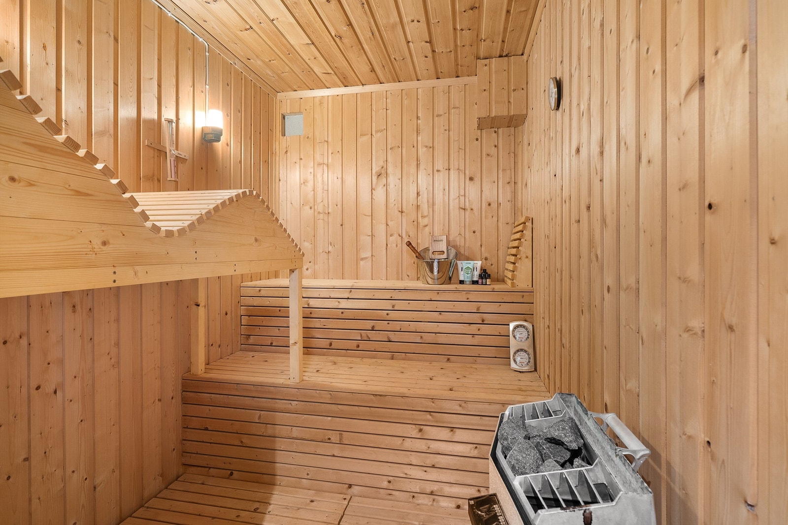 Badstue med plassbygde benker i tre og badstueovn av merke "Tylø" på 6 kw Galleribilde