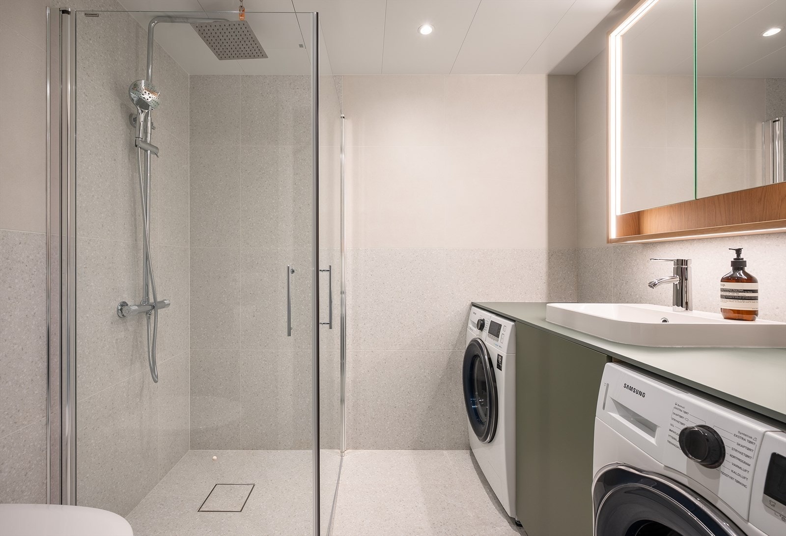 Baderom av god størrelse, med opplegg for vaskemaskin og tørketrommel Galleribilde