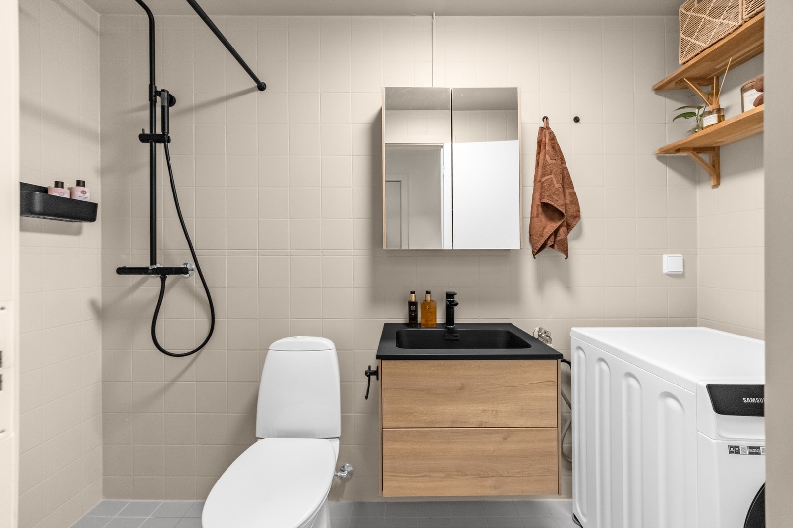 Stort flislagt bad med gulvvarme. Badet har dusjhjørne, gulvfestet klosett, servant og opplegg for vaskemaskin. Galleribilde