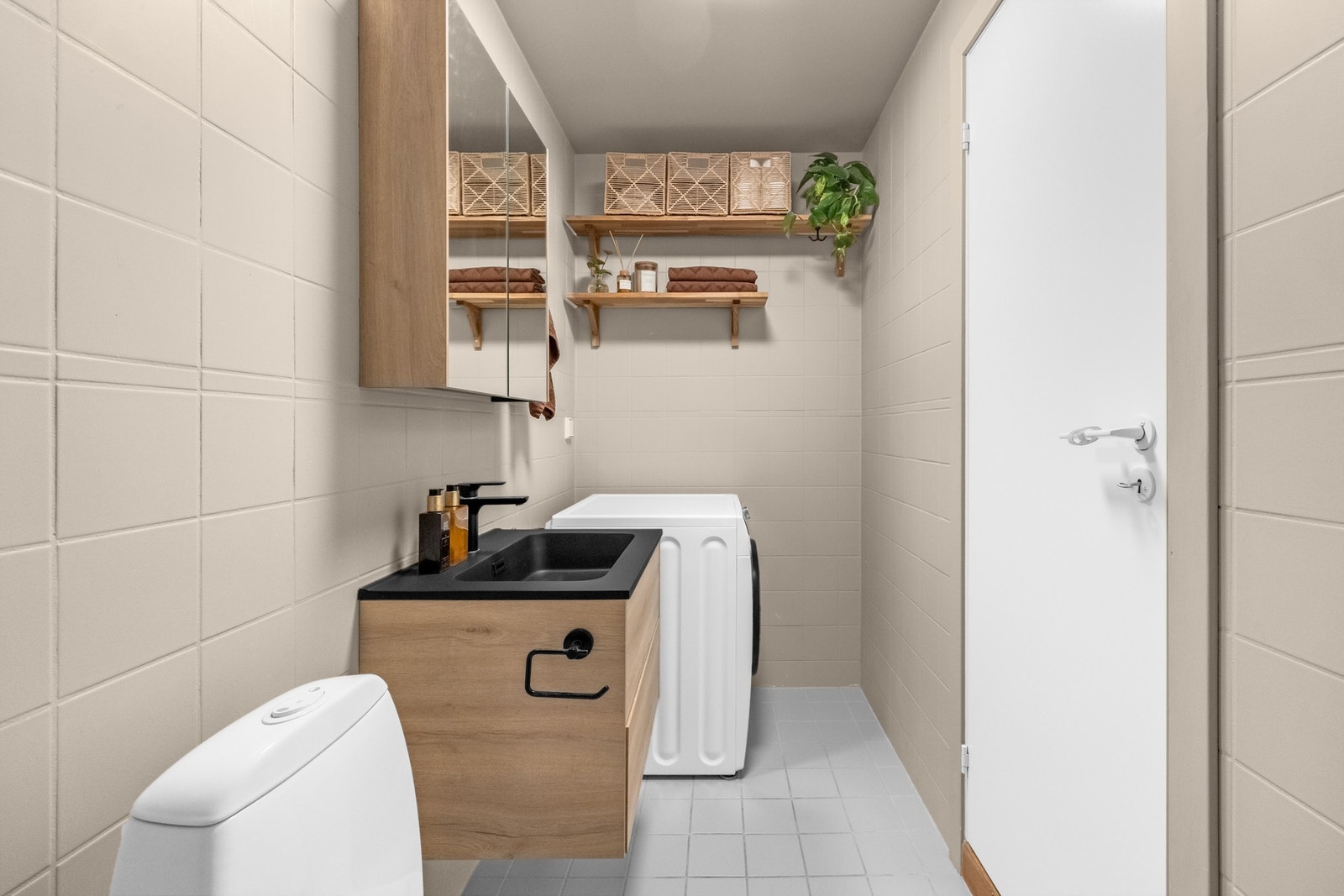 Benkeskap med glatte fronter, stort speil og opplegg for vaskemaskin. Galleribilde