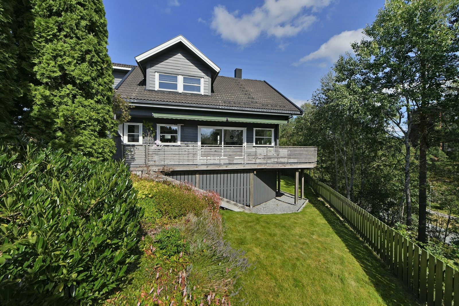 Uteområde - inngjerdet tomt med gressplen, diverse beplanting, m.m. - her kan barna leke i trygge omgivelser Galleribilde