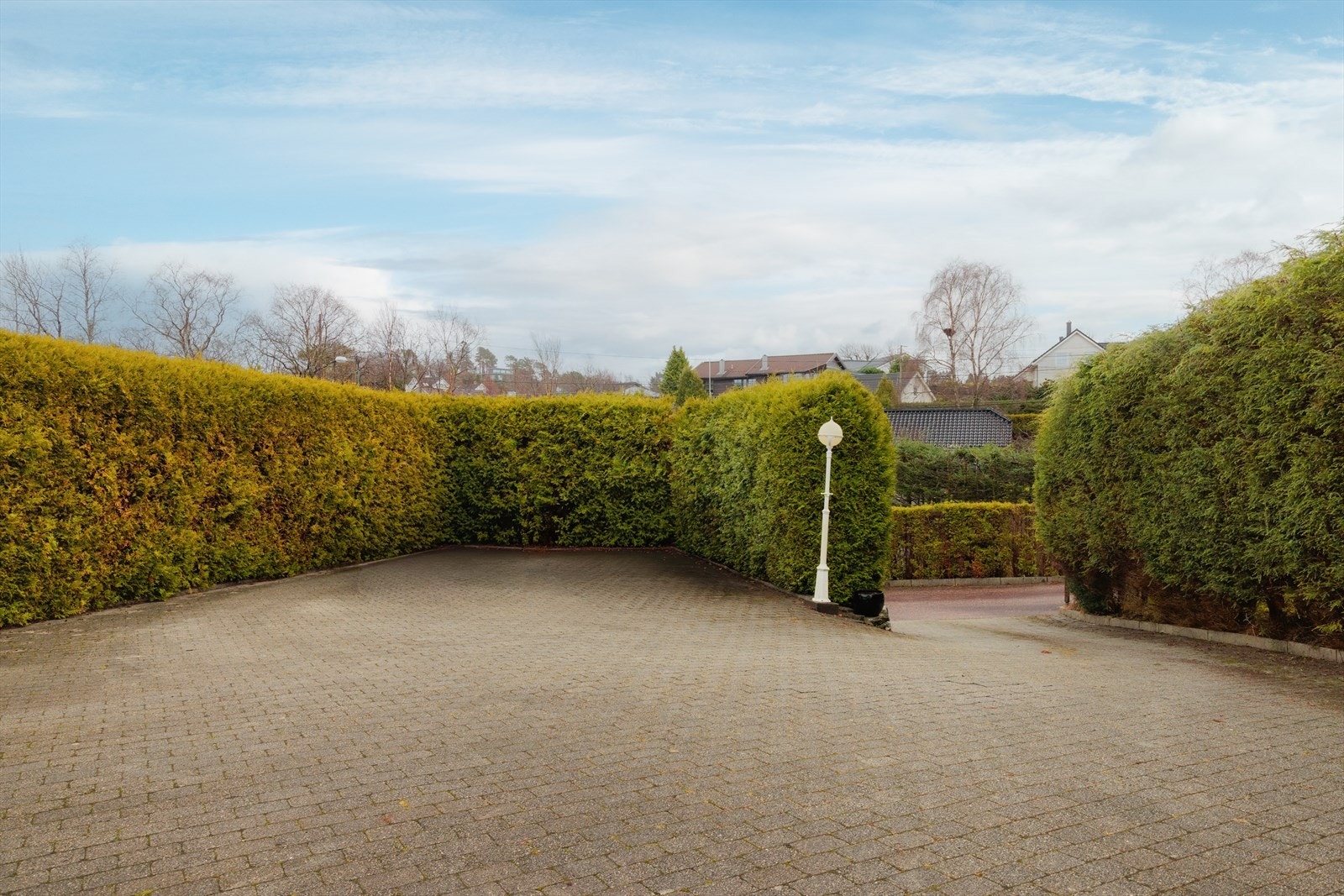 Stor og usjenert uteplass med mange parkeringsplasser. Varmekabler i innkjørsel. Galleribilde