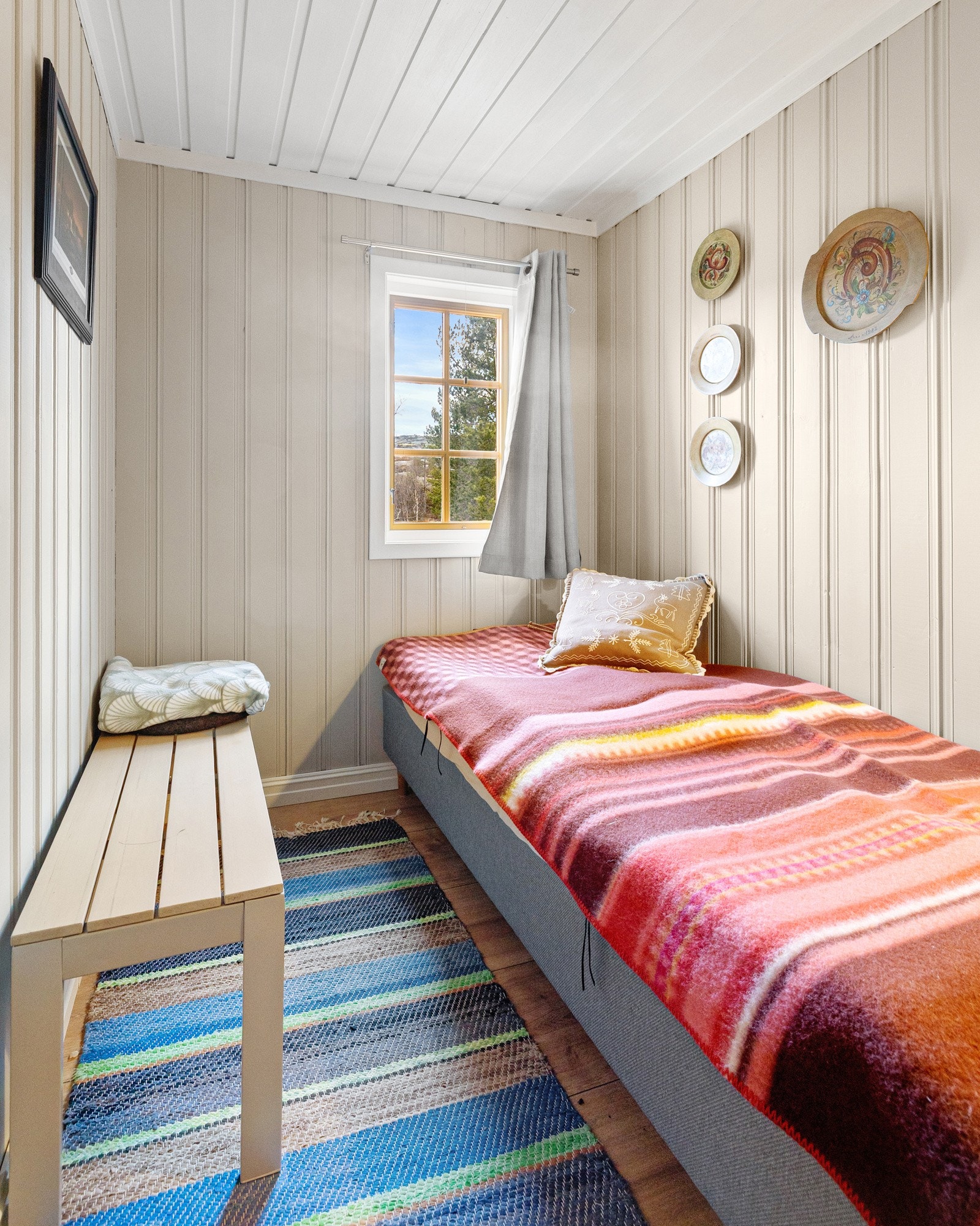 Rommene har gjennomgående trepanel på vegger, tregulv og vinduer som gir naturlig lys og utsyn mot grønne omgivelser. Soverom 3. Galleribilde