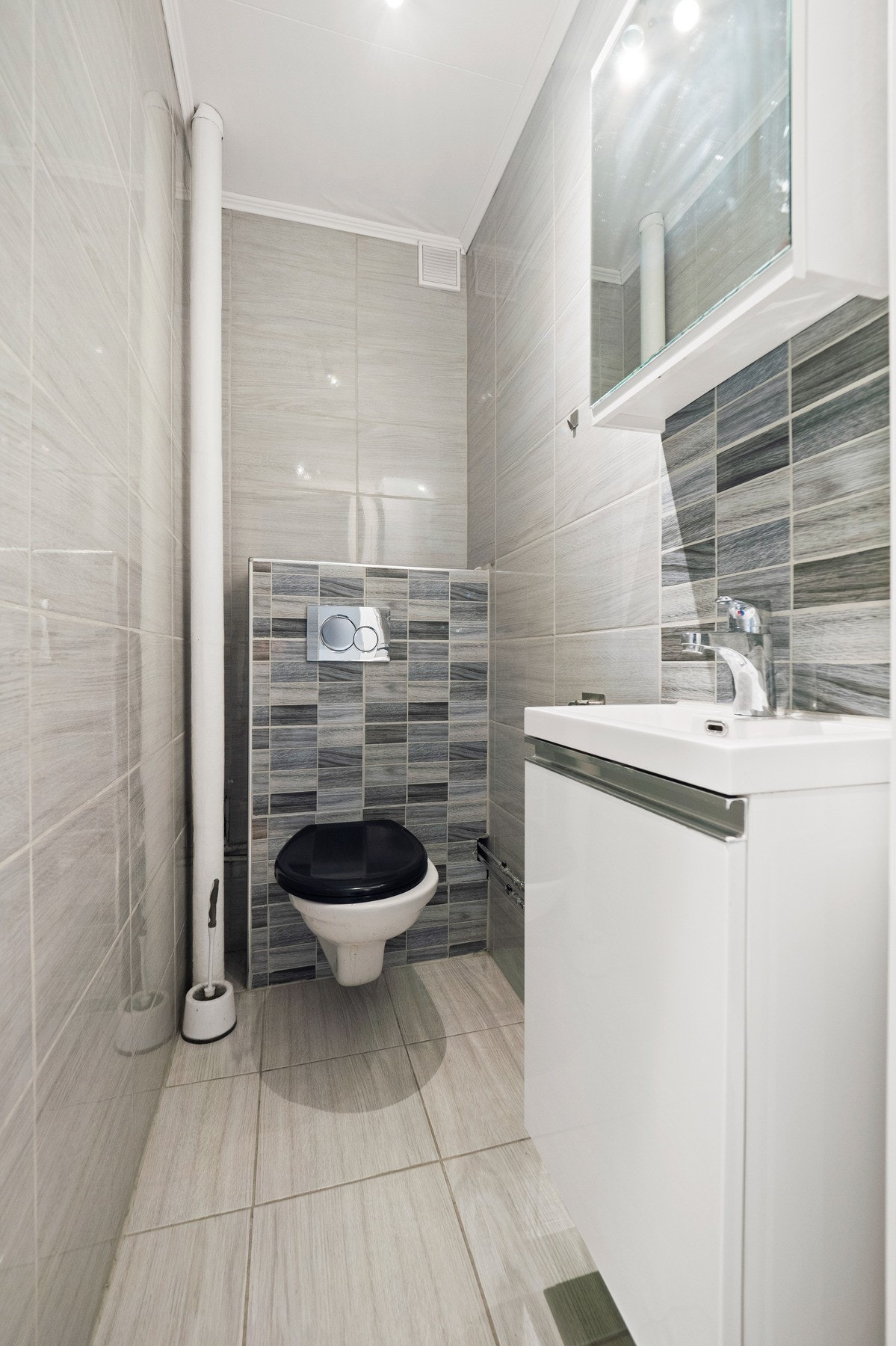 Leiligheten har også et praktisk toalettrom med fliser, lys innredning og innbygget toalett. Galleribilde