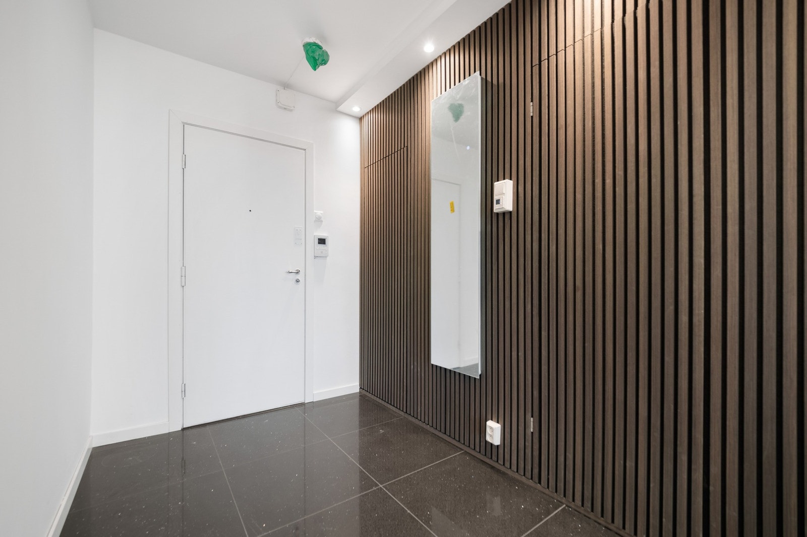 Stilfullt inngangsparti med fliser på gulv og spilevegg. Galleribilde