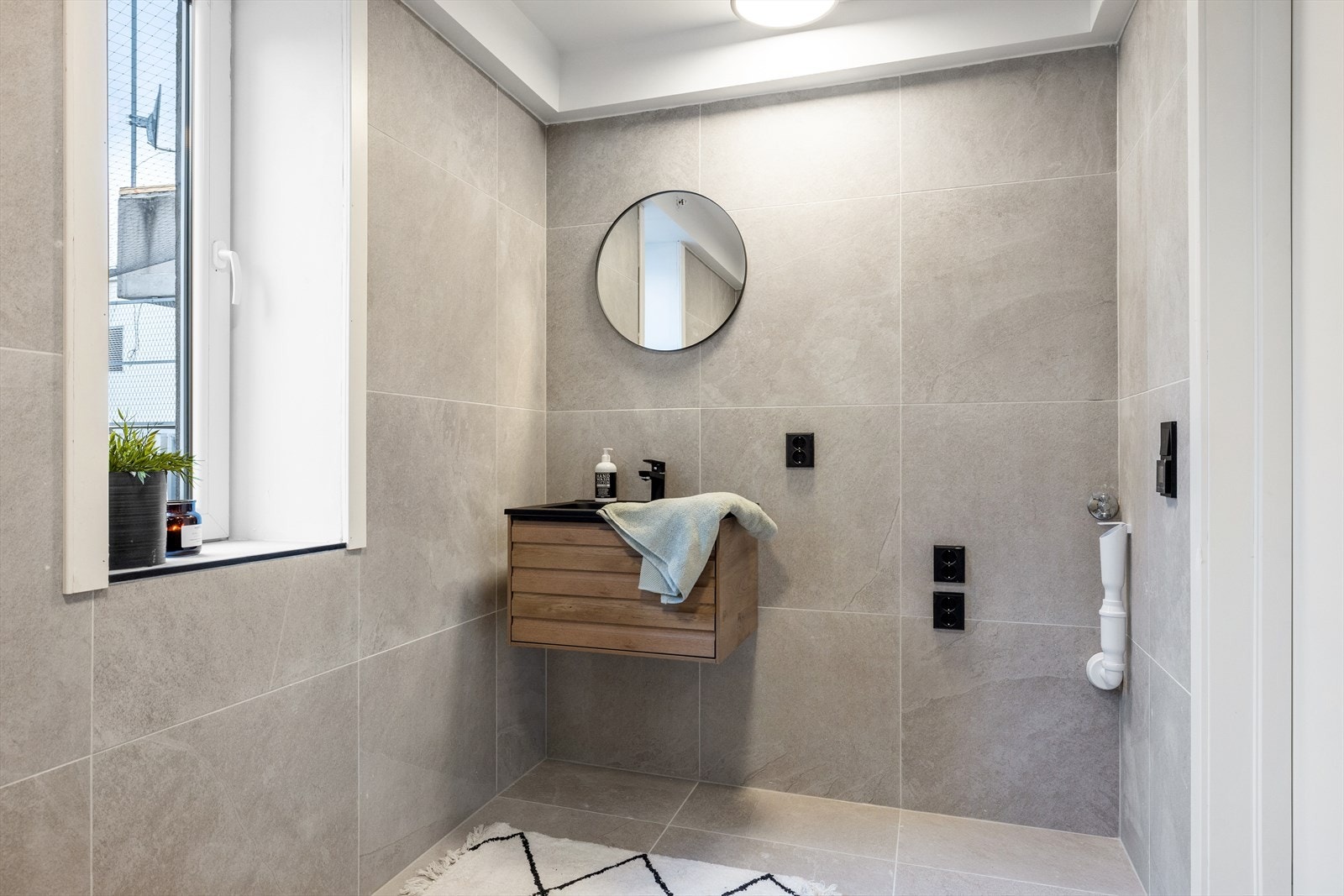 På badet er det dusjnisje, vegghengt toalett, servant med innredning og opplegg for vaskerom Galleribilde