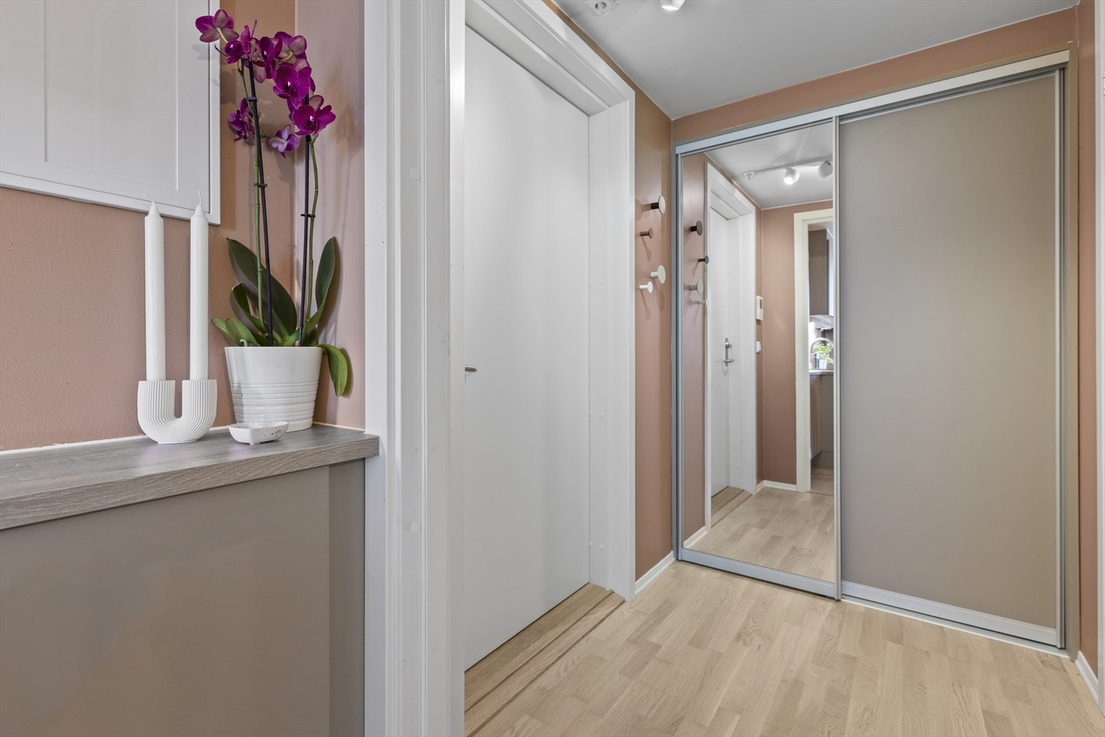 Det er montert skyvedørsgarderobe med speilfront på endeveggen, og plass til skohylle på gulvet. Galleribilde