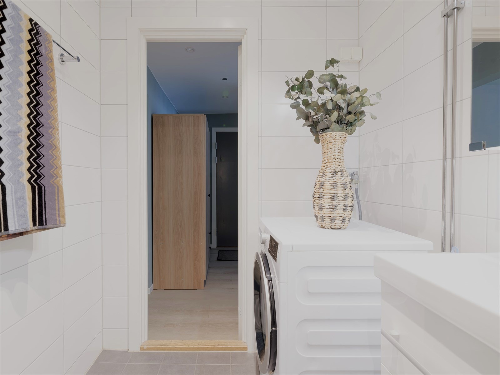 Et velunyttet rom med flislagte overflater i en lys og tidsnøytreal utførelse. Galleribilde