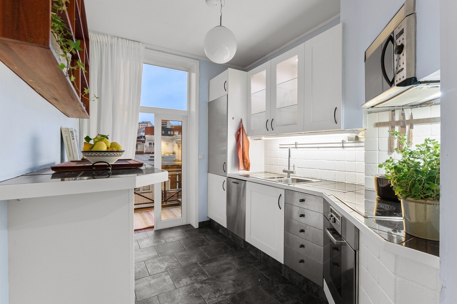 Moderne kjøkkeninnredning, utført i lyse glatte og profilerte fronter med god skap- og benkeplass. Galleribilde