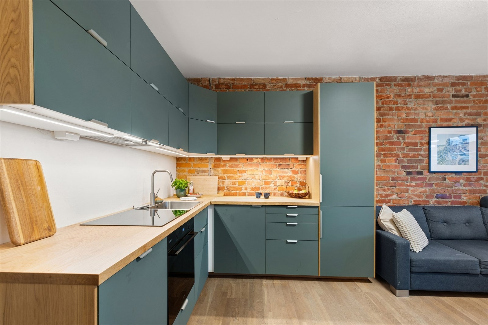 Teglsteinsveggen skaper en rustikk, varm og lun atmosfære i leiligheten. Galleribilde