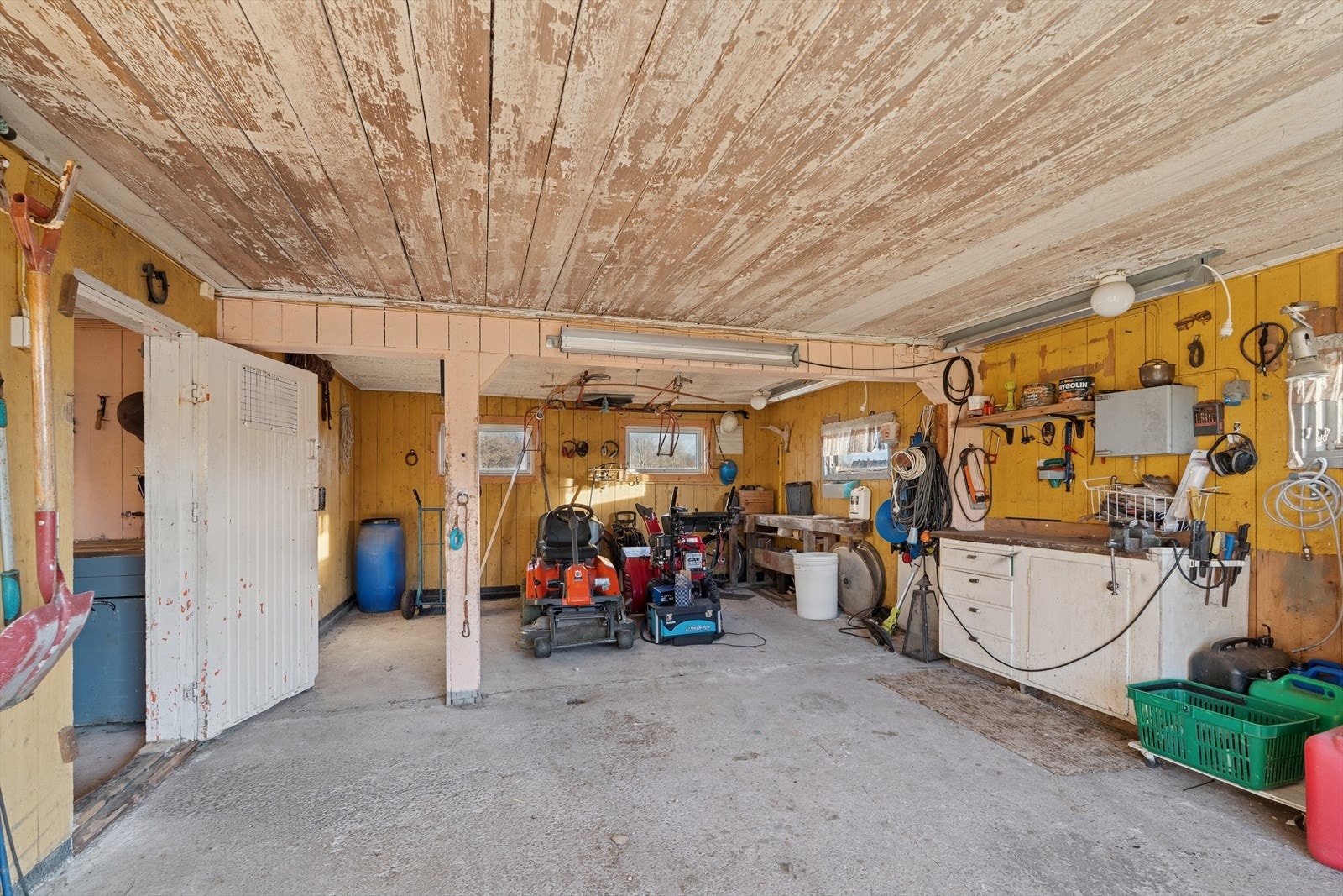 Stor garasje med plass til både kjøretøy og utstyr som gjør det enkelt å vedlikeholde småbrukets behov Galleribilde