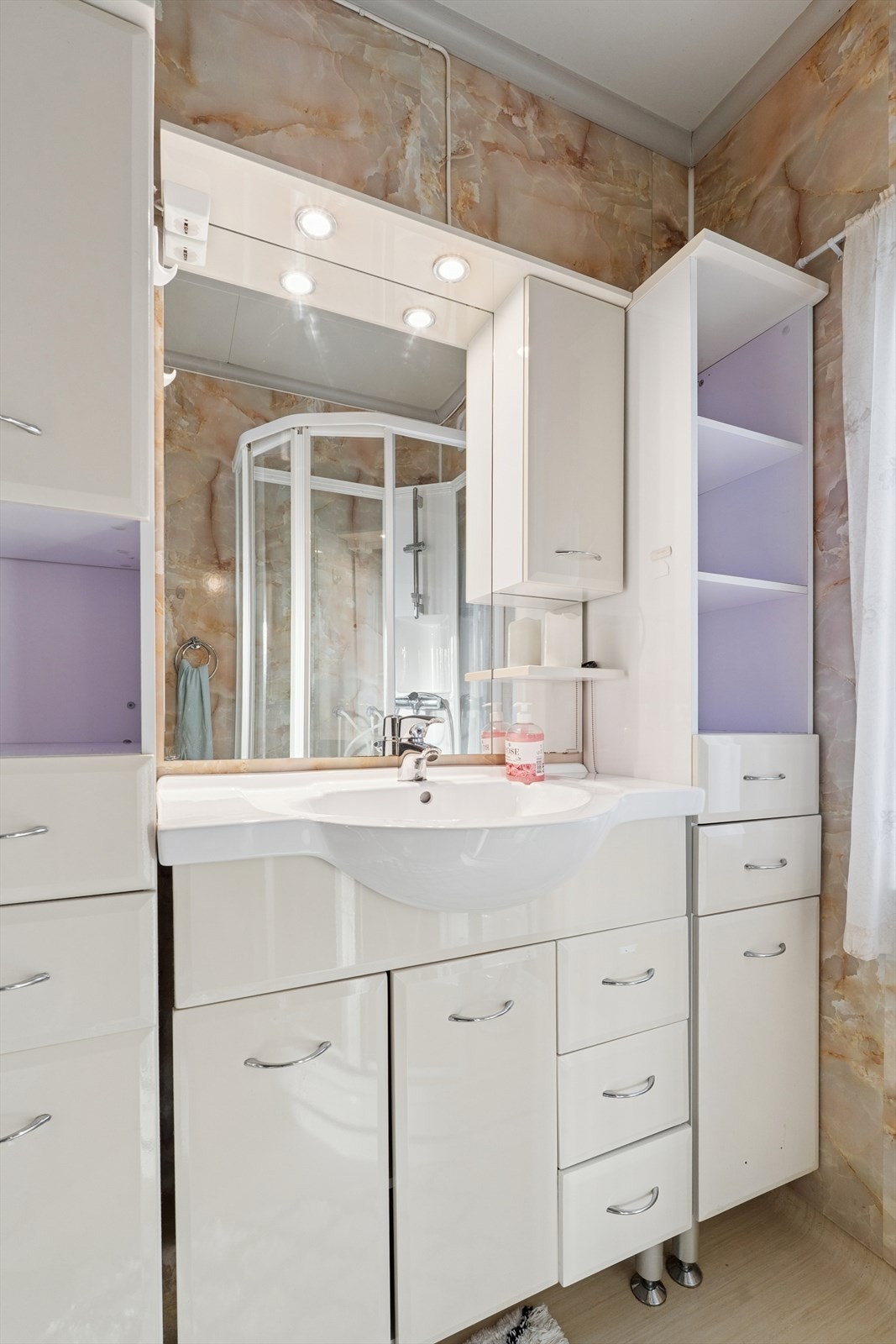 Rommet har dusjkabinett, toalett og baderomsinnredning i lys utførelse med mye oppbevaringsplass Galleribilde