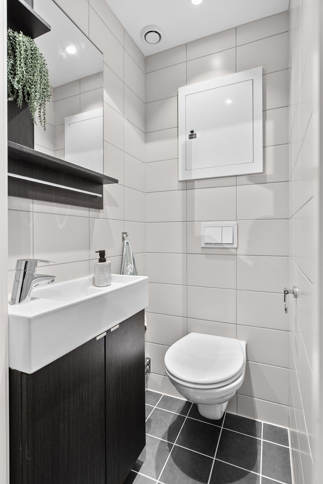 Separat toalettrom med fliser og moderne sanitærutstyr. Downlights og praktisk servantløsning. Galleribilde