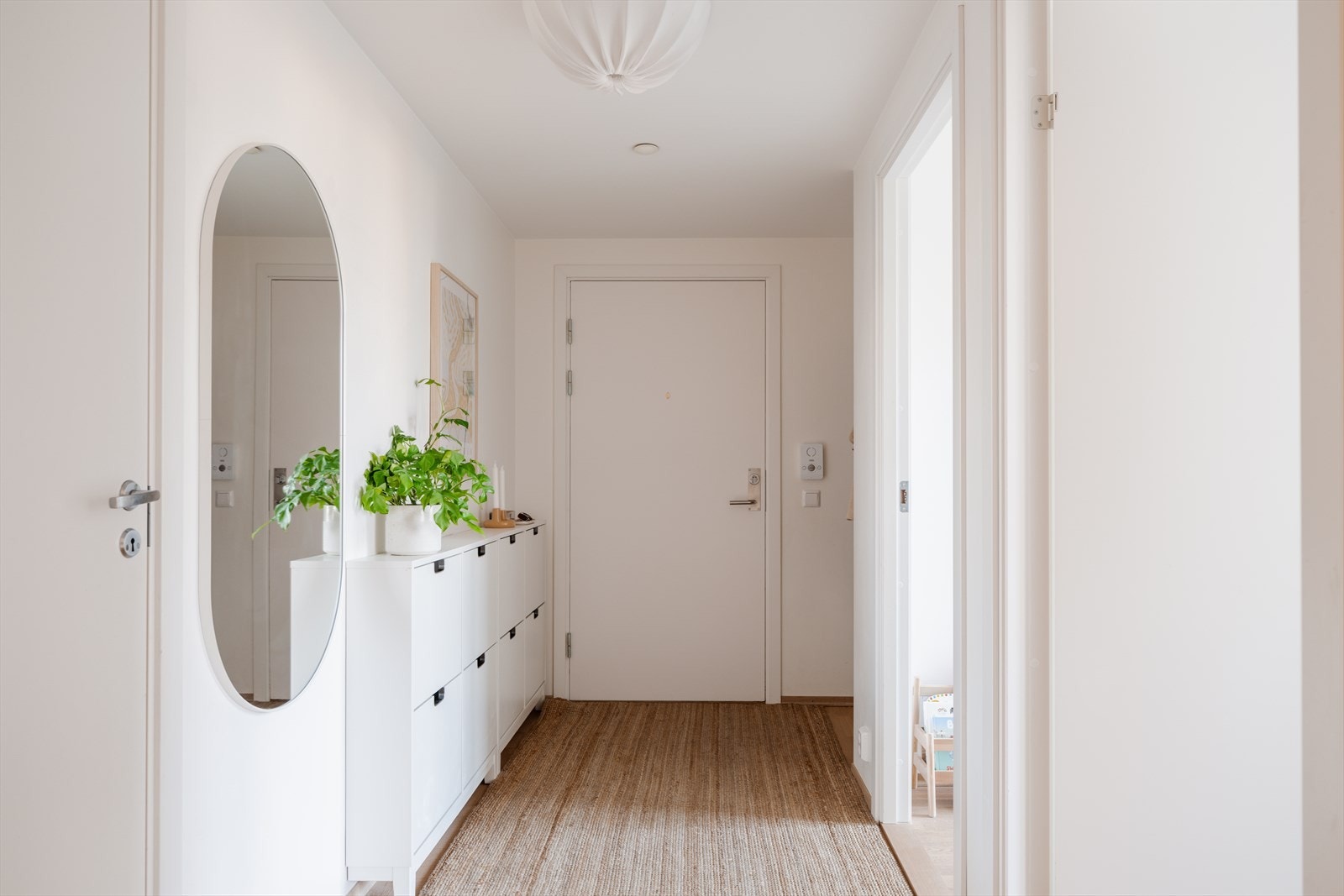 Velkommen inn i en lys entré med 3-stavs parkett på gulvet, som er gjennomgående i leiligheten. Galleribilde