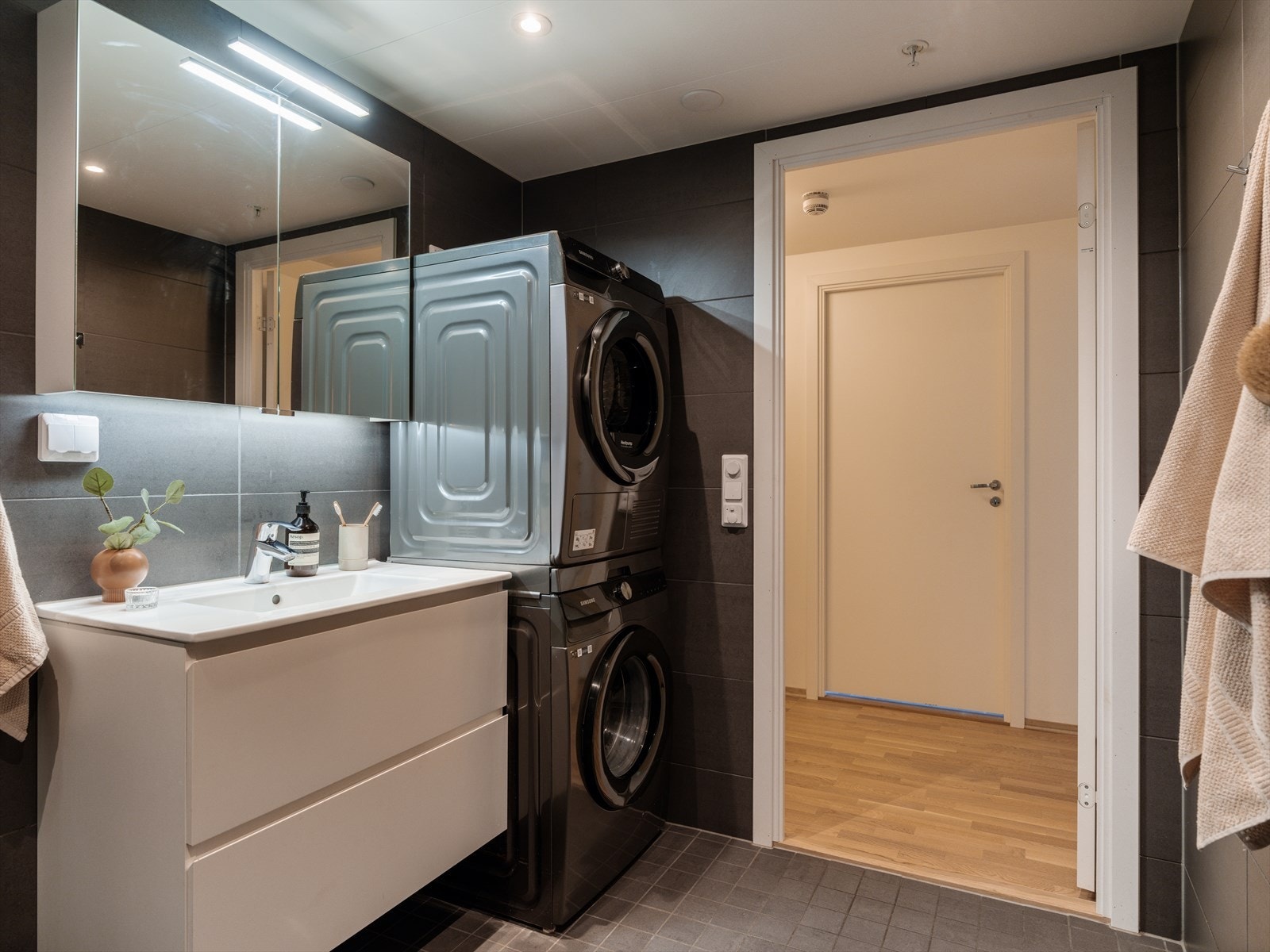 Servantskap med heldekkende servant, speilskap med lys og opplegg for både vaskemaskin og tørketrommel. Galleribilde