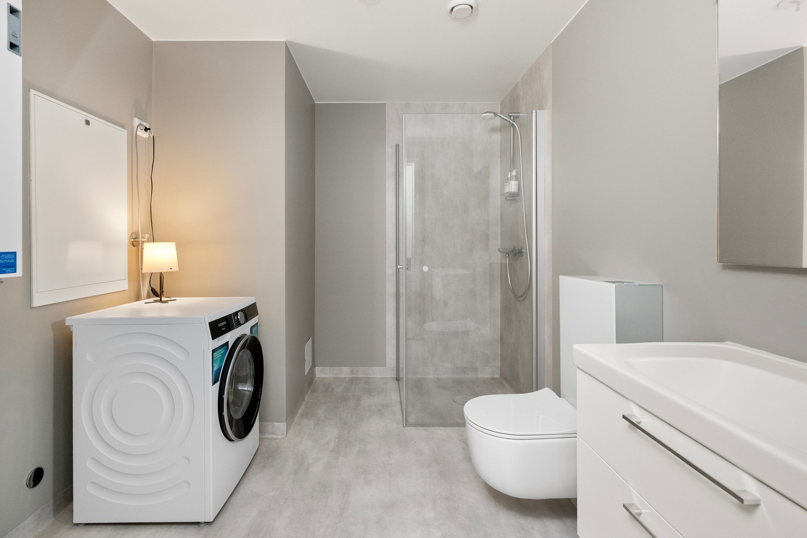 Moderne baderom med dusjhjørne, vegghengt toalett. Lyse farger gir et stilrent inntrykk. Galleribilde