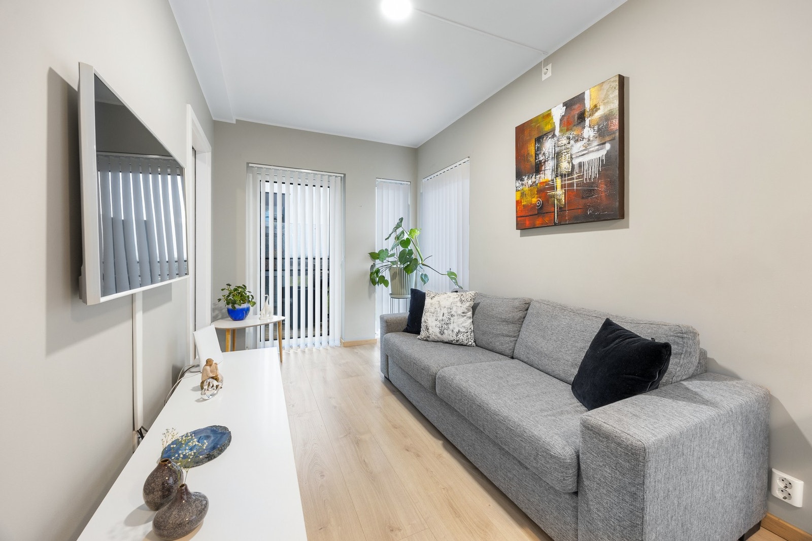 Den åpne stuen fremstår som meget innbydende i lyse, delikate fargevalg. Store vindusflater fra gulv til tak slipper inn rikelig med lys og den flotte takhøyden på hele 2,52 meter gir en luftig romfølelse. Galleribilde